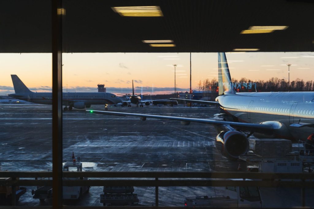 Uitzicht op vliegtuigen op de startbaan bij zonsondergang, klaar voor vertrek met reizigers die vliegtickets Dubai hebben geboekt