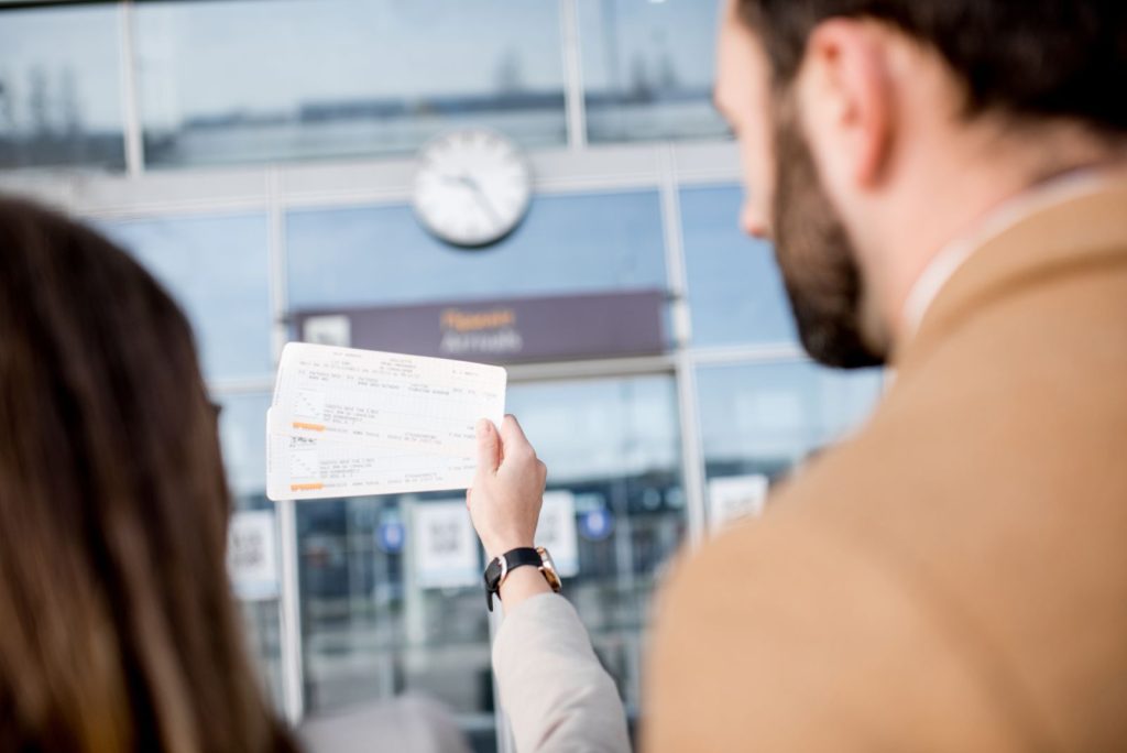 Close-up van een koppel dat hun vliegtickets Milaan vasthoudt op de luchthaven, klaar voor vertrek